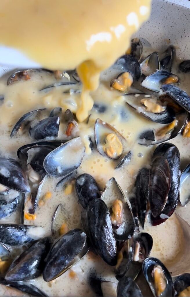 Add the cream-egg mixture to the sauce in the casserole dish, stir and allow to thicken slightly. Return the mussels to the sauce,